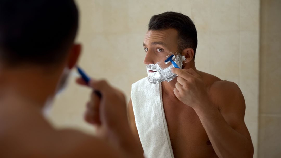 man shaving cheek