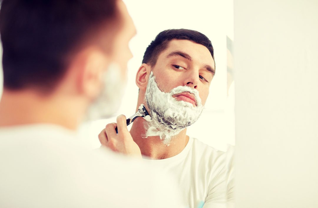 man shaving in mirror
